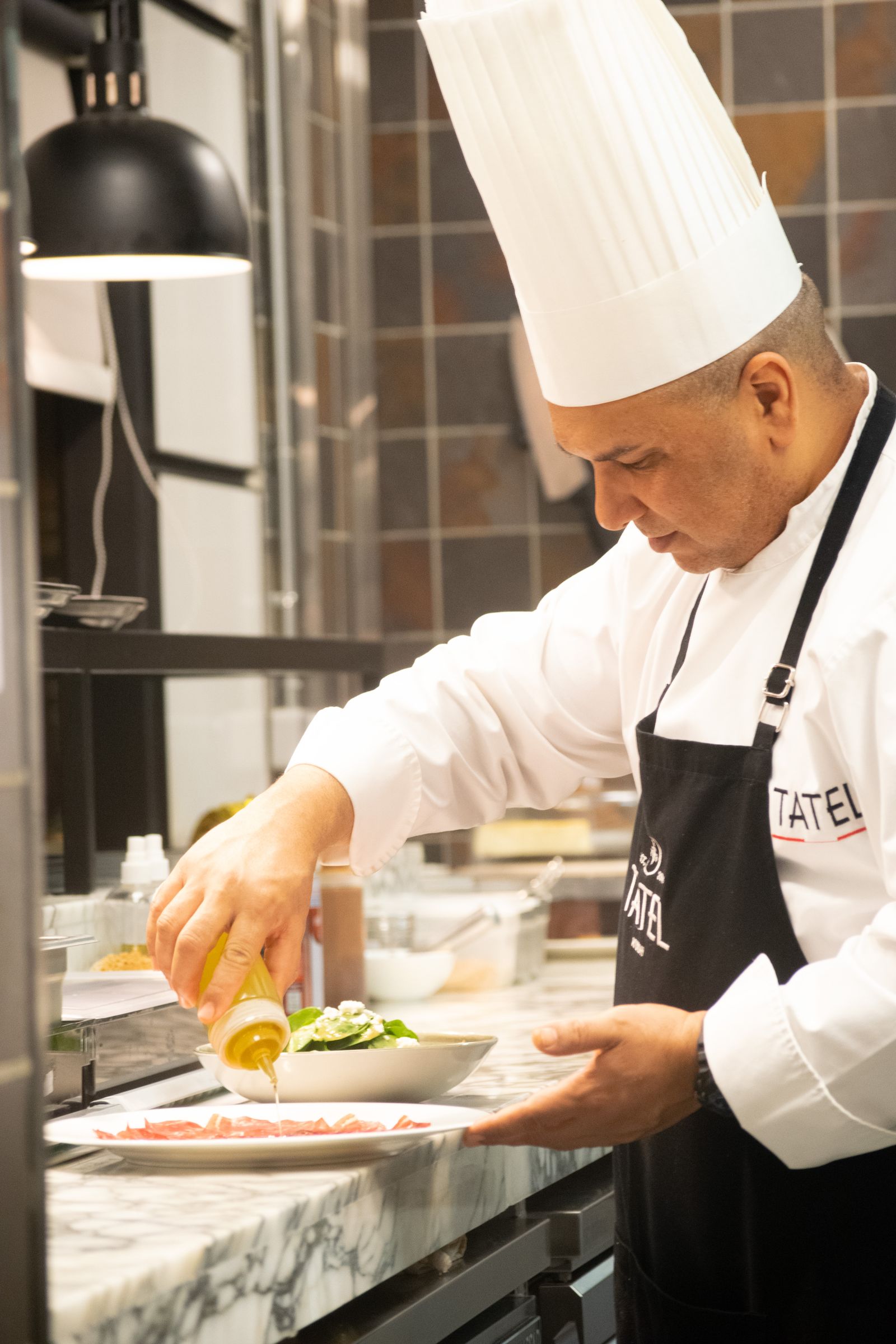 Chef preparing a plated dish in a professional kitchen — illustrative stock photograph